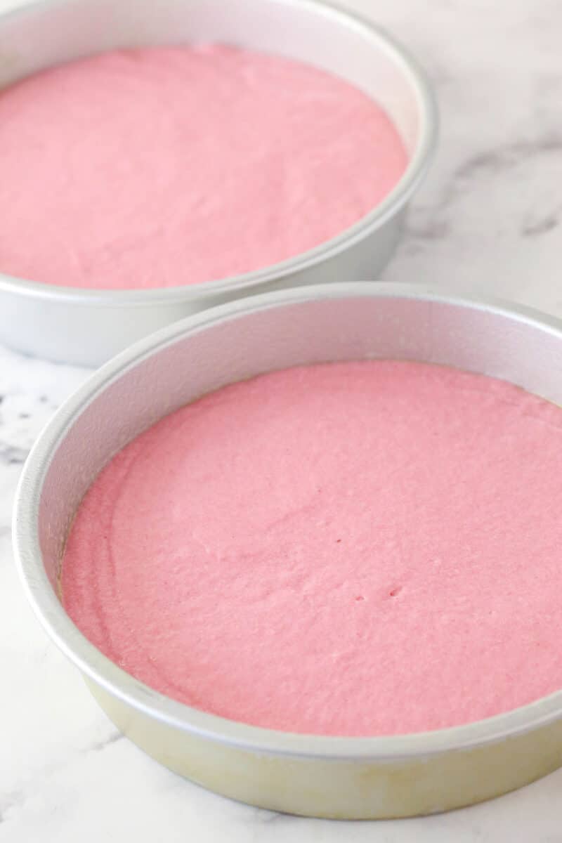 Strawberry cake batter divided into two cake pans.