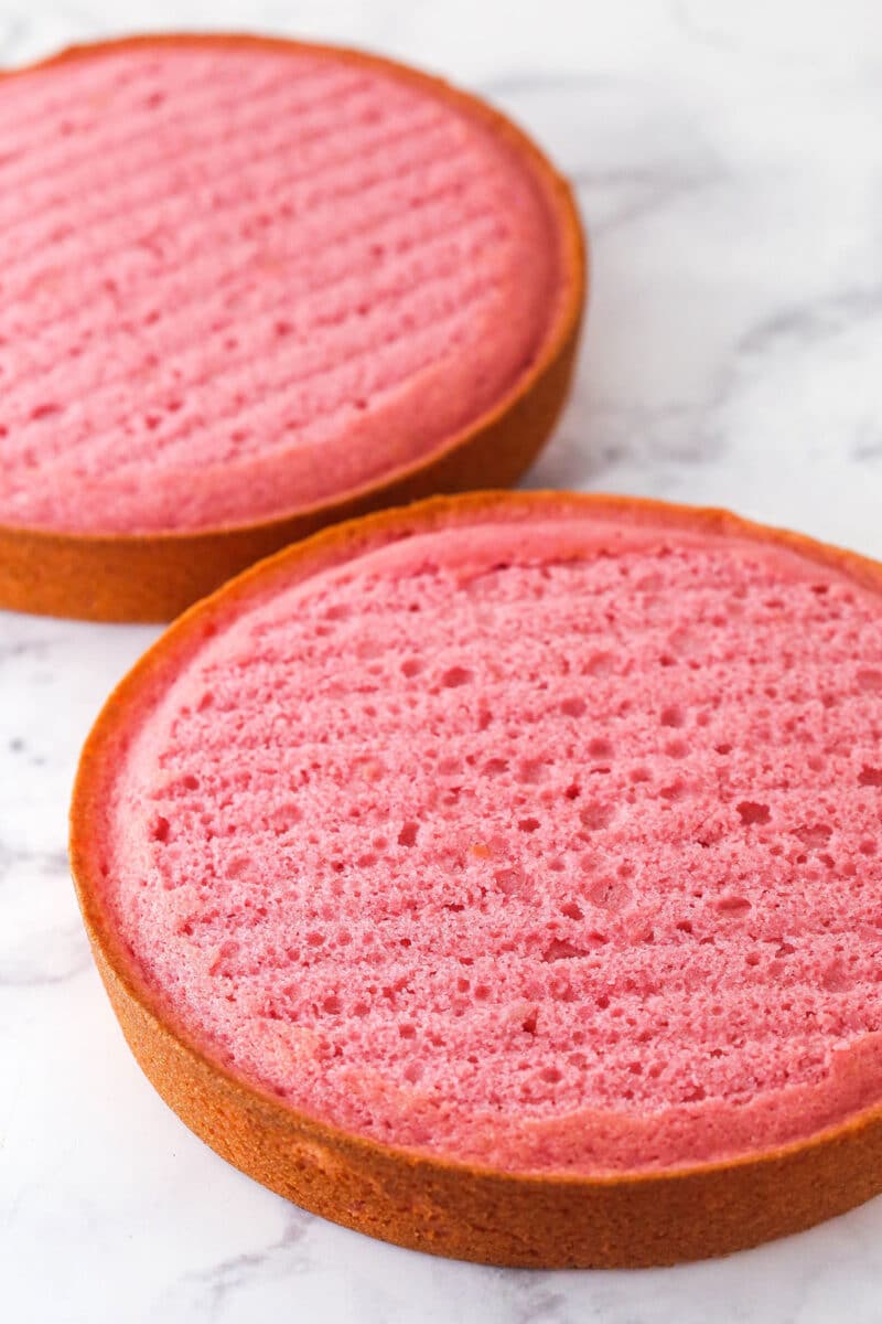 Two strawberry cake layers with domes removed.