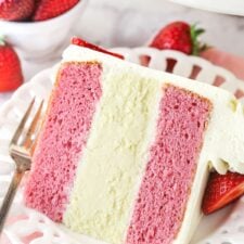 A slice of strawberries and cream cheesecake cake on a plate.