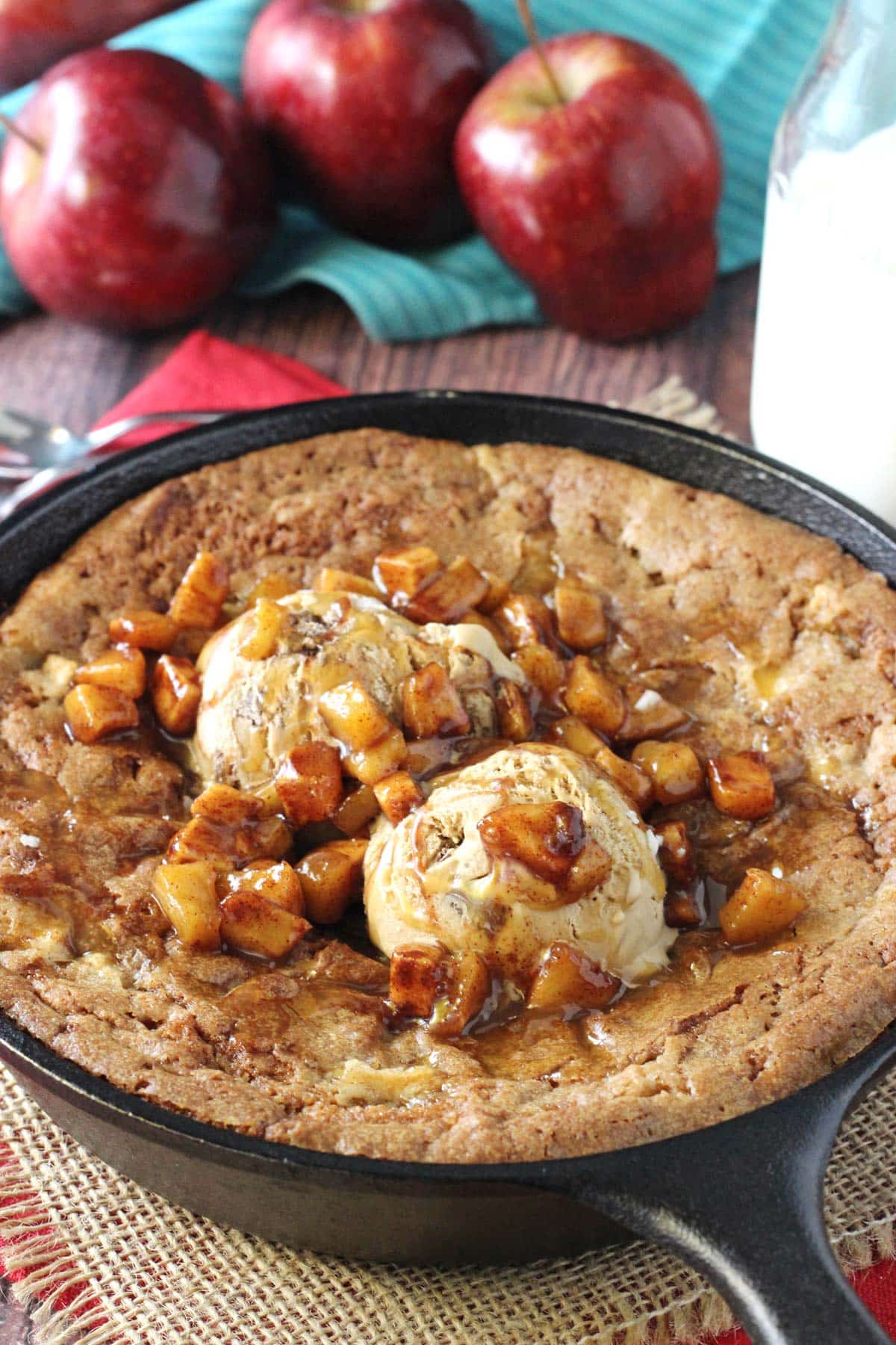 Close up of an apple cinnamon skillet blondie with ice cream and apples on top.