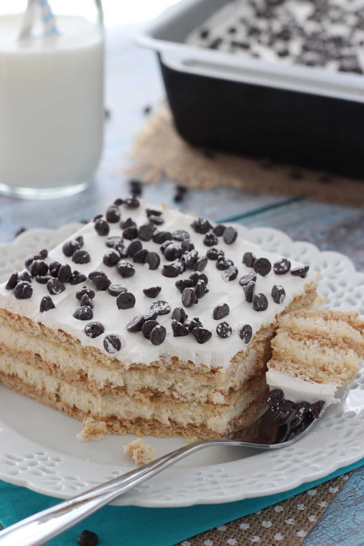 A slice of cannoli icebox cake with a bite removed on a fork.
