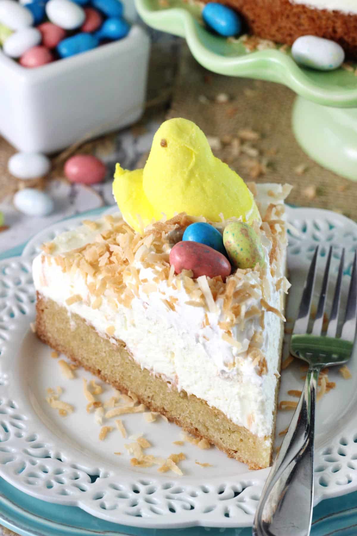 Close up of a slice of coconut blondie cheesecake on a white plate.