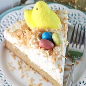 A slice of coconut blondie cheesecake on a white plate.