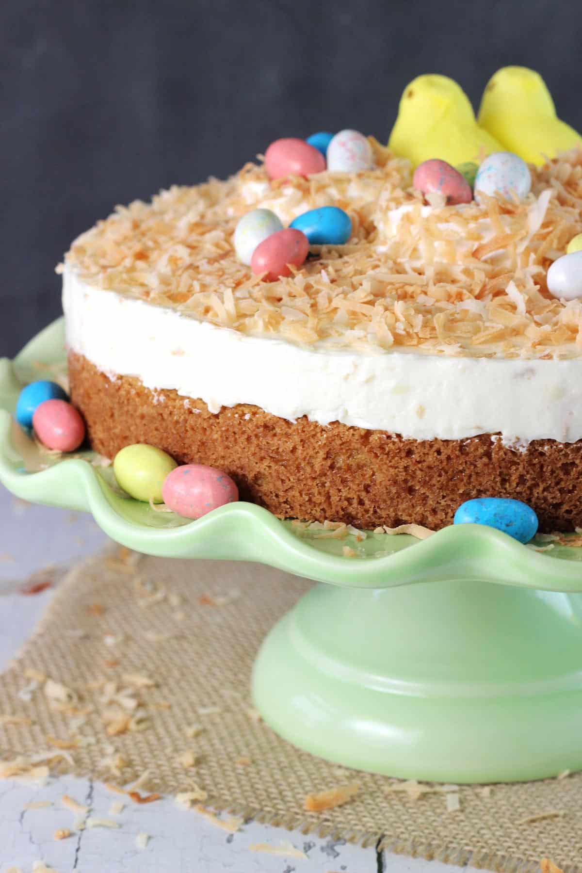 Close up of a coconut blondie cheesecake on a green cake stand.