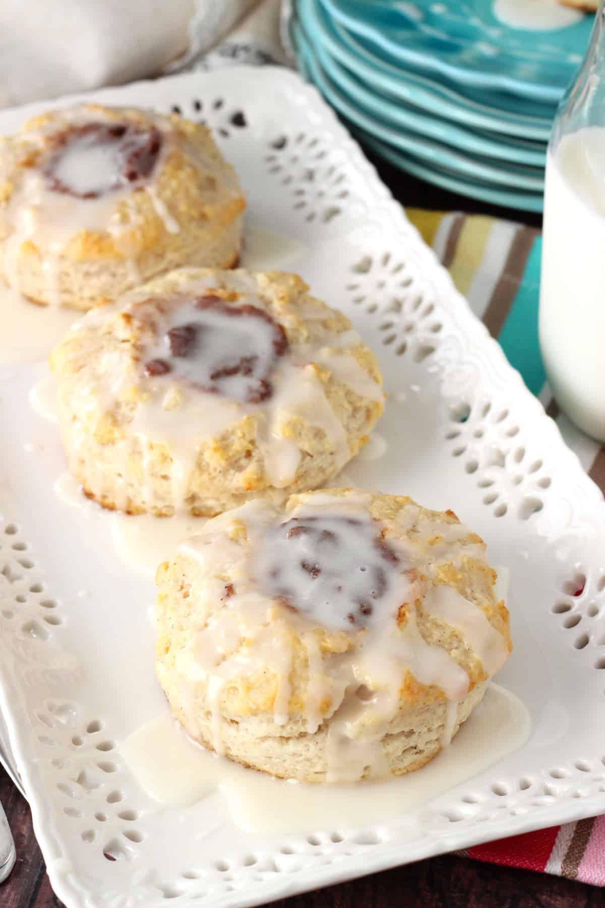 Three cinnamon biscuits on a white tray.
