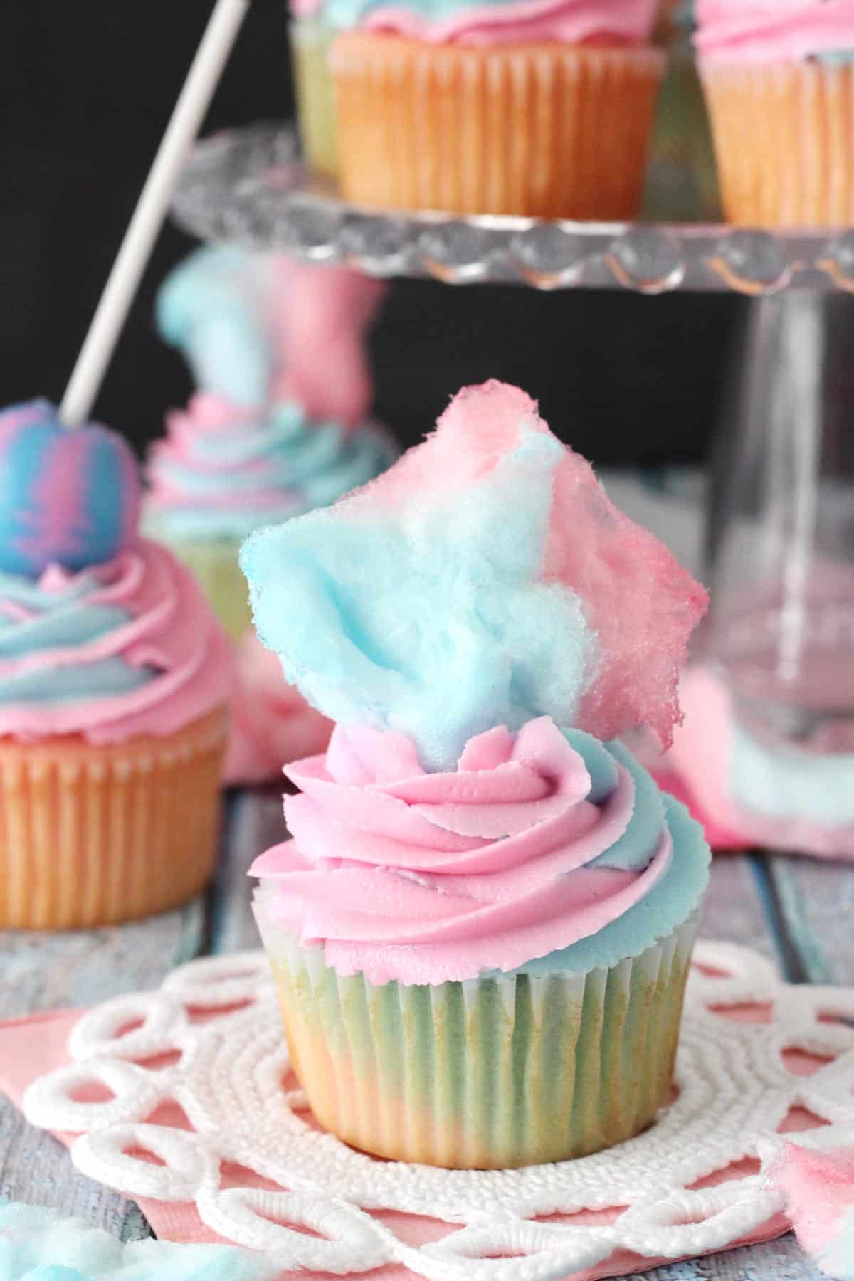 Close up of a cotton candy cupcake with cotton candy on top.