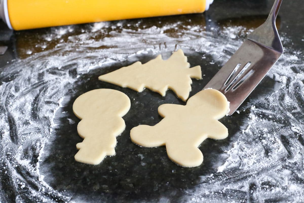 A spatula lifting a cutout sugar cookie.