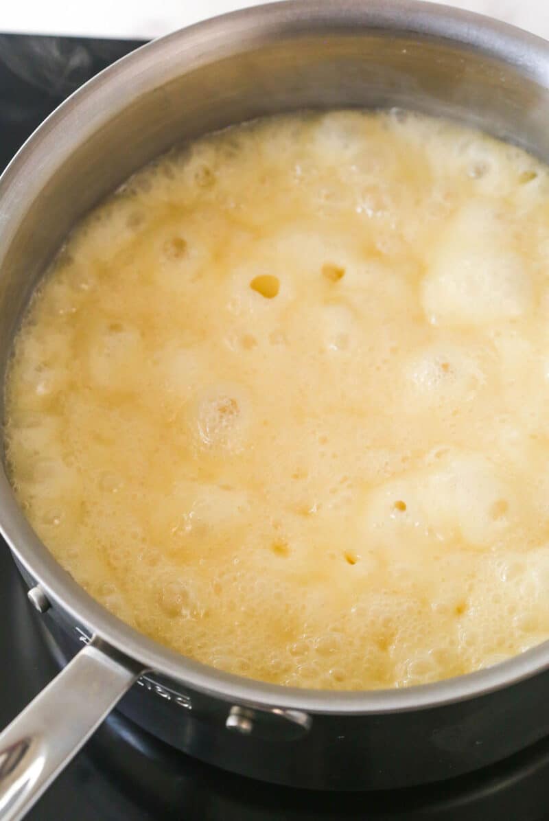 Butter, sugar, and evaporated milk boiling in a saucepan.