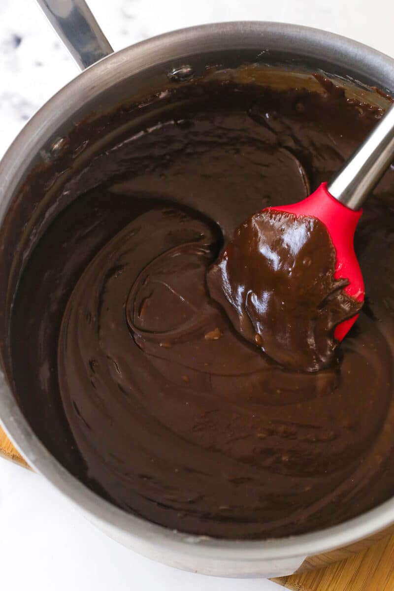Stirring chocolate into cooked butter, sugar, and evaporated milk to make fantasy fudge.
