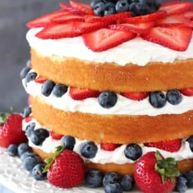Side view of a fresh berry vanilla layered cake.