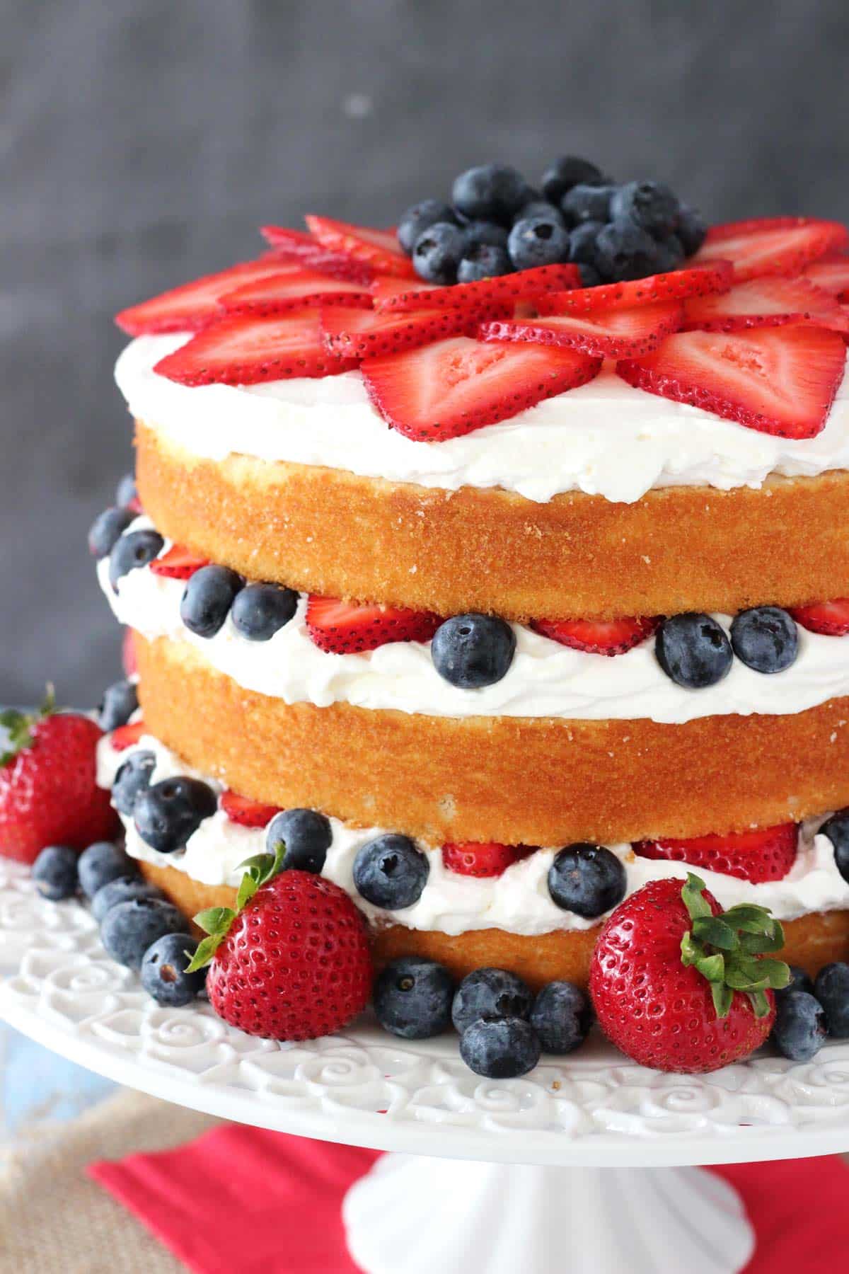 Side view of a fresh berry vanilla layered cake.