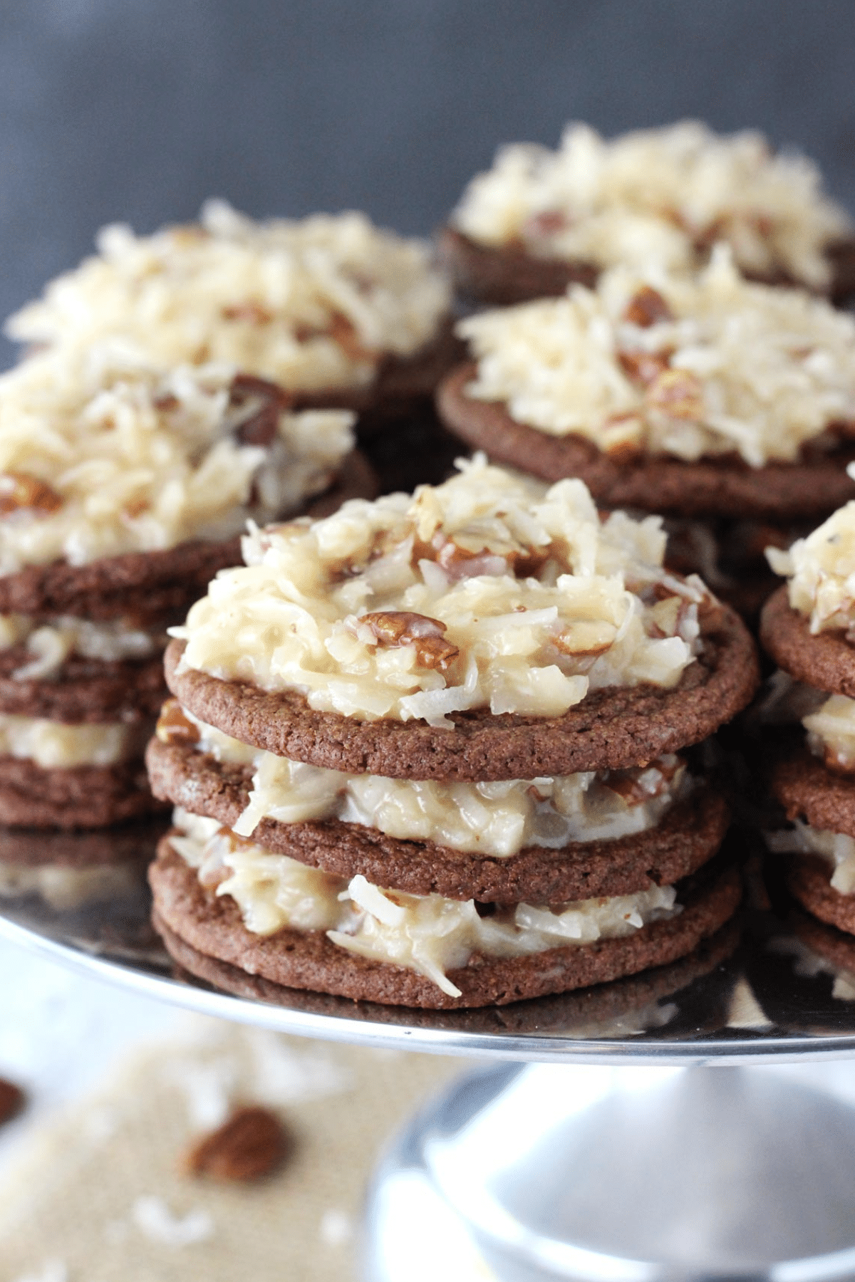 Close up of German chocolate cookie stacks on a silver cake stand.