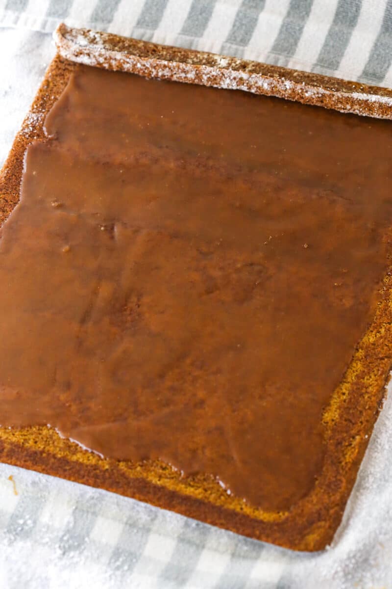 Gingerbread cake roll is a fun alternative to the classic, featuring a moist, spiced cake wrapped around a caramel and cream cheese filling. Spread caramel sauce over the cake.