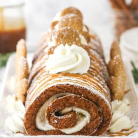 Gingerbread cake roll decorated with cream cheese whipped cream and gingerbread men.