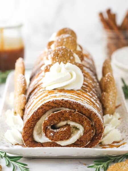 Gingerbread cake roll decorated with cream cheese whipped cream and gingerbread men.
