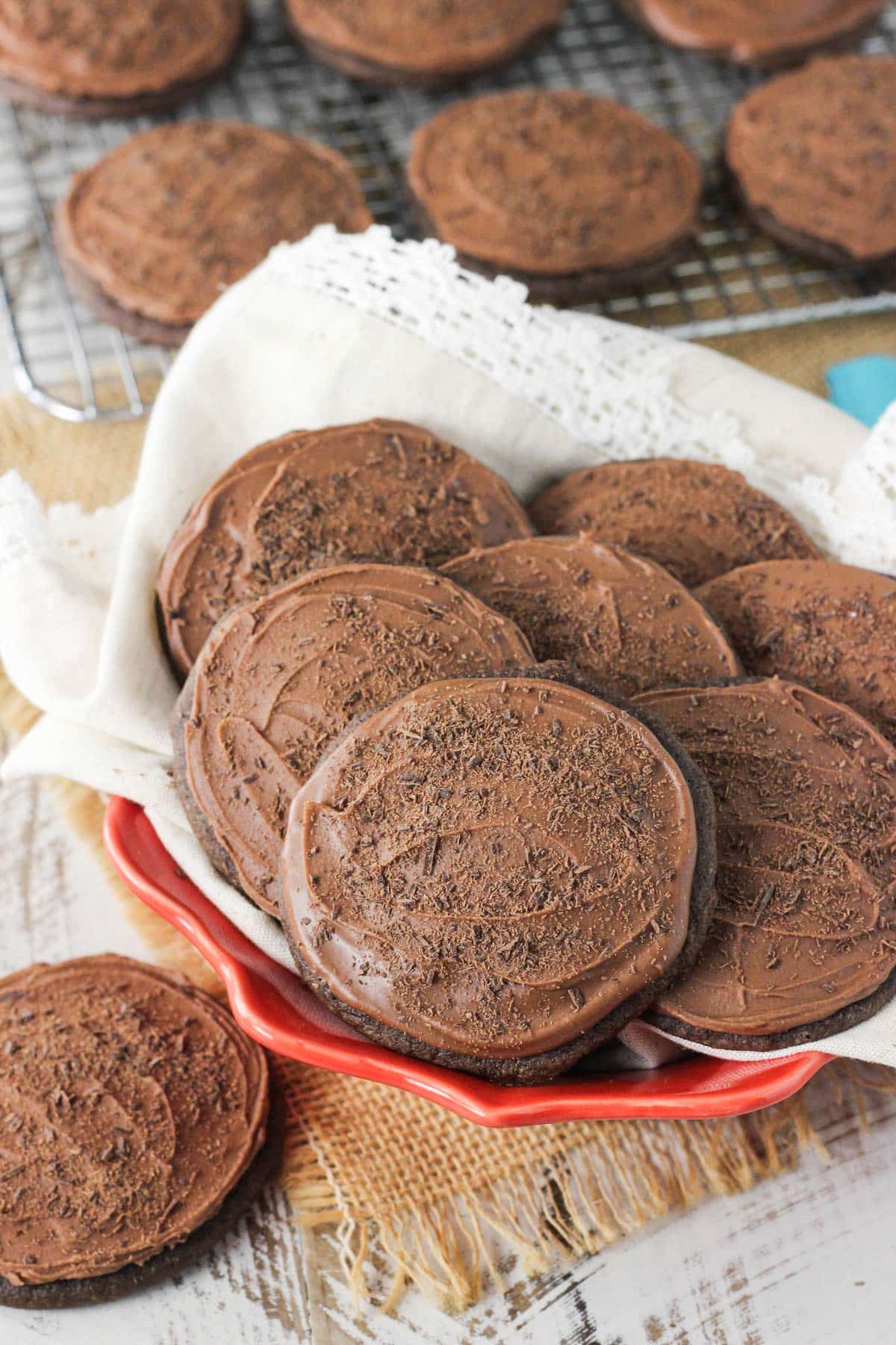 A red bowl filled with iced chocolate cookies.