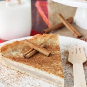 A slice of milk tart on a white plate.