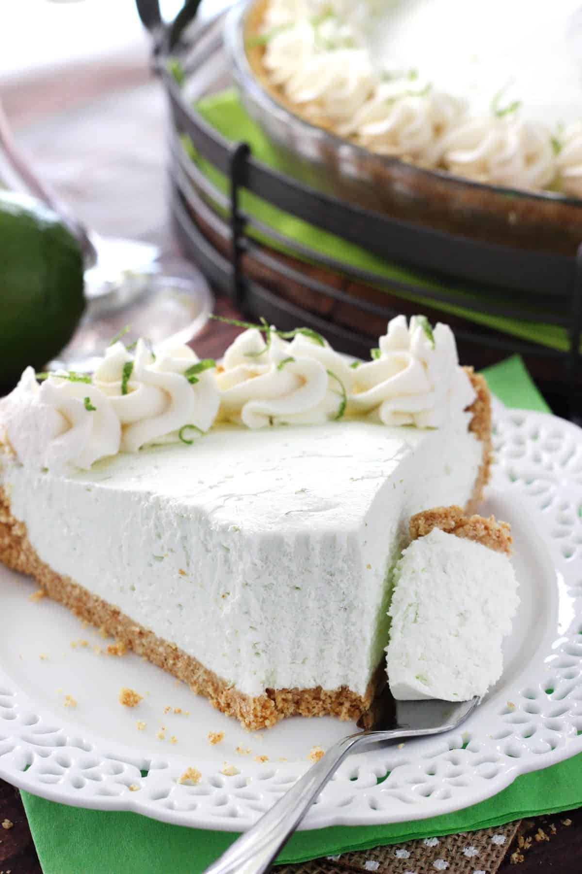Close up of a slice of no bake margarita pie with a bite removed on a fork.