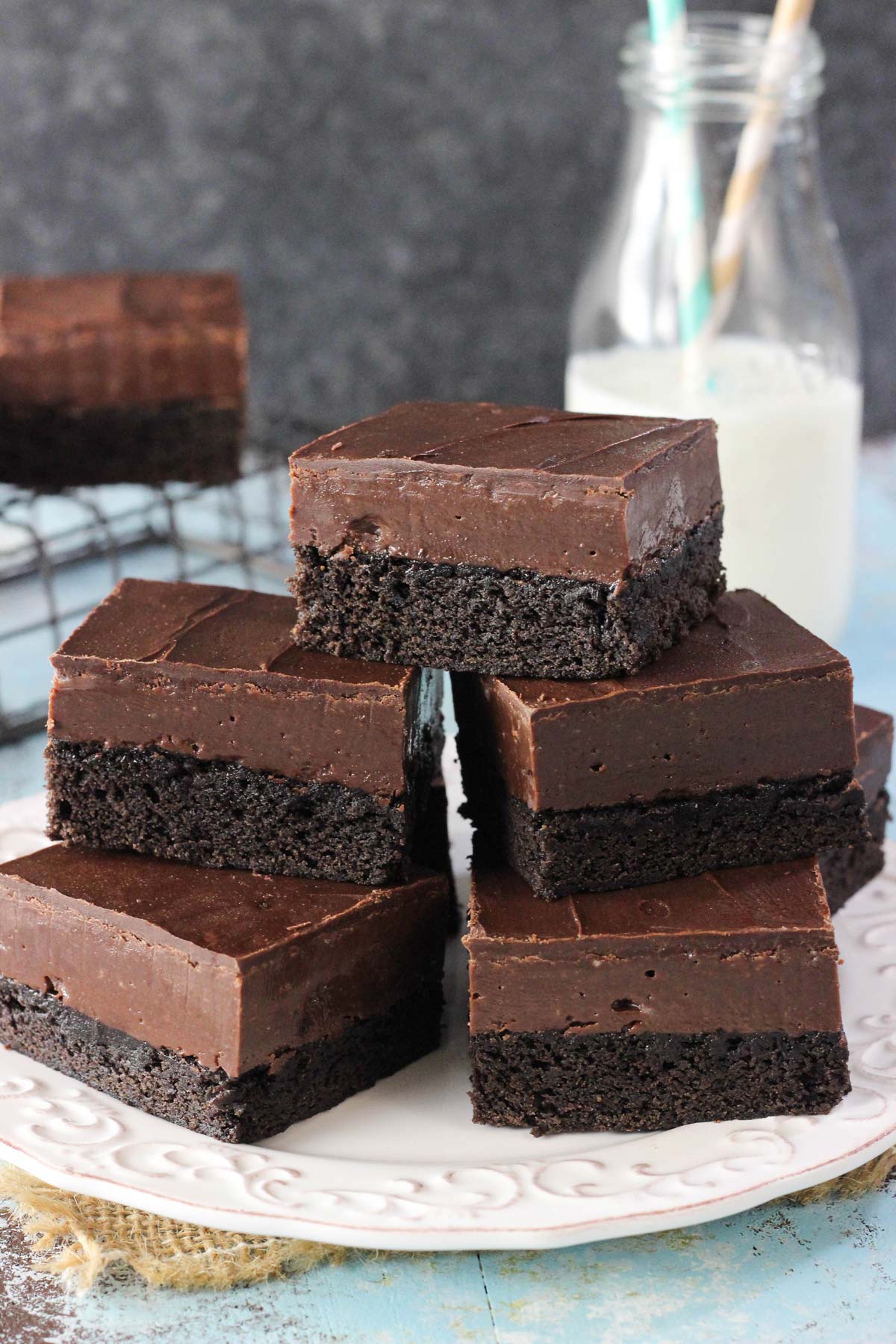 Close up of stacked Nutella fudge brownies on a small white plate.
