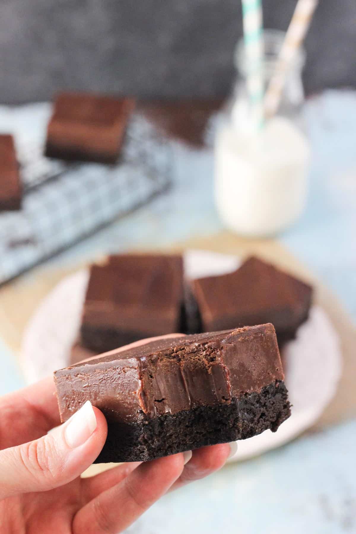 Hand holding up a Nutella fudge brownie with a bite out of it.