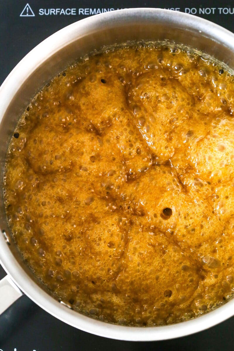 This saltine cracker toffee is rich, buttery, and full of crispy crackers. With a chocolate topping and crunchy pecans, it's a holiday must! Boiling butter and light brown sugar to make toffee.