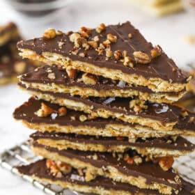 Saltine cracker toffee pieces stacked on a cooling rack.