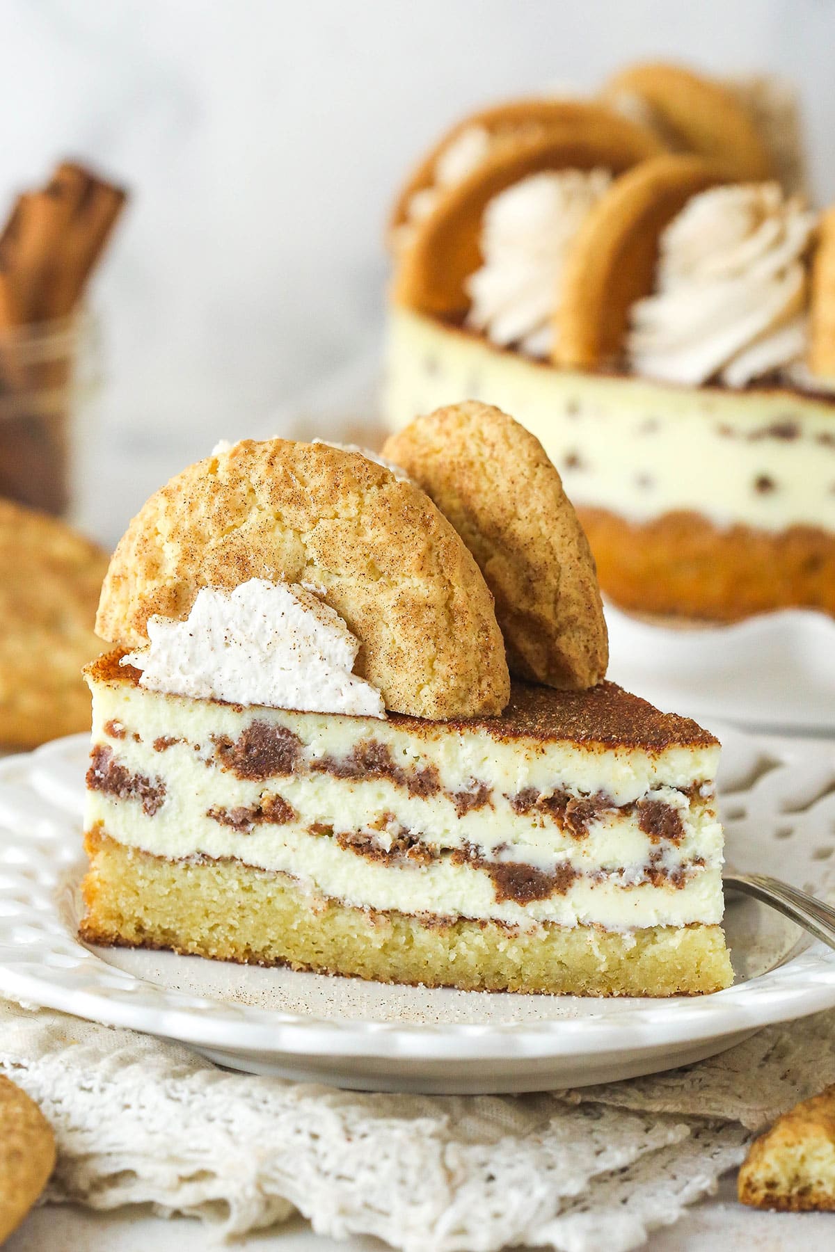 Side view of a slice of snickerdoodle cheesecake on a plate.