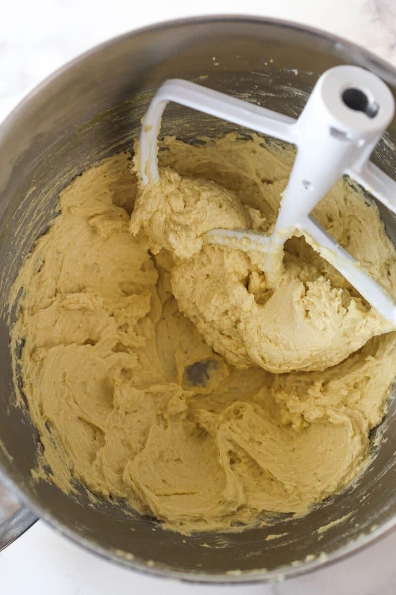 These decadent turtle thumbprint cookies feature a rich chocolate base, gooey caramel center, and crunchy pecan coating. Wow! Adding eggs and vanilla to creamed butter and sugars to make cookie dough.