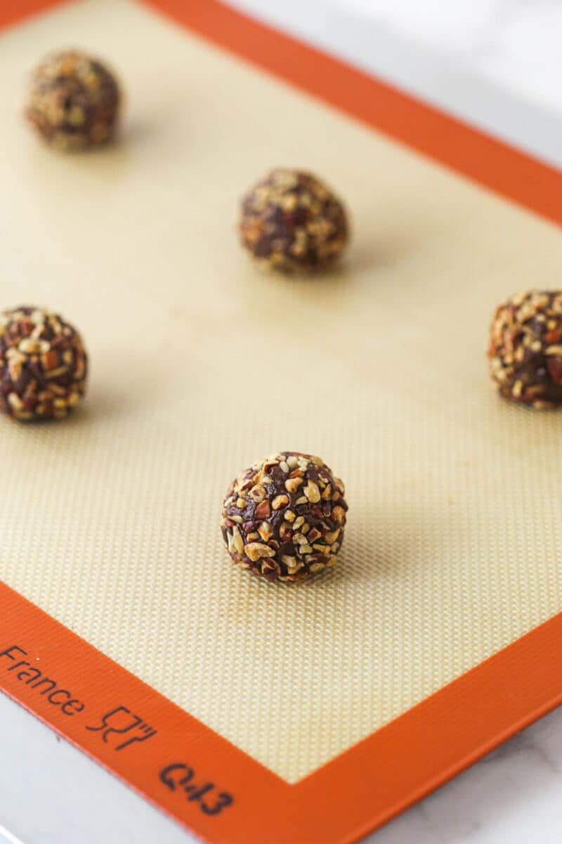 These decadent turtle thumbprint cookies feature a rich chocolate base, gooey caramel center, and crunchy pecan coating. Wow! Pecan-crusted chocolate cookie dough balls.