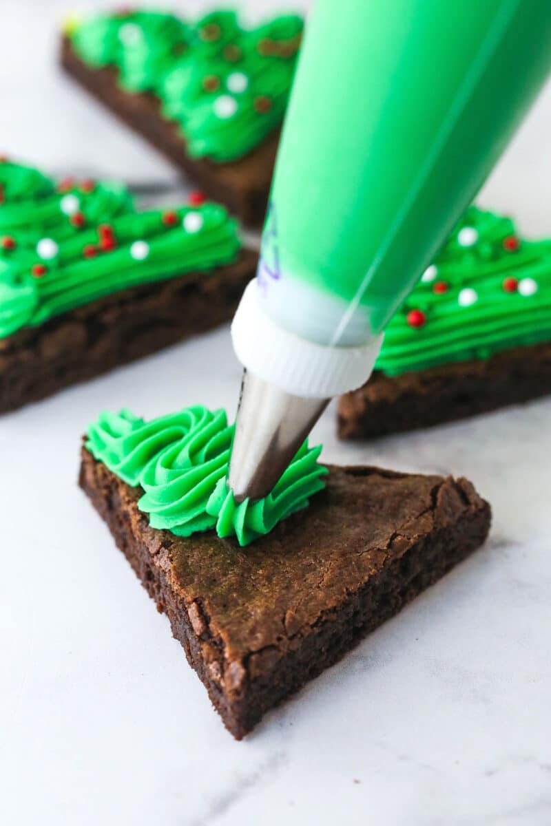 putting green frosting onto christmas tree brownie