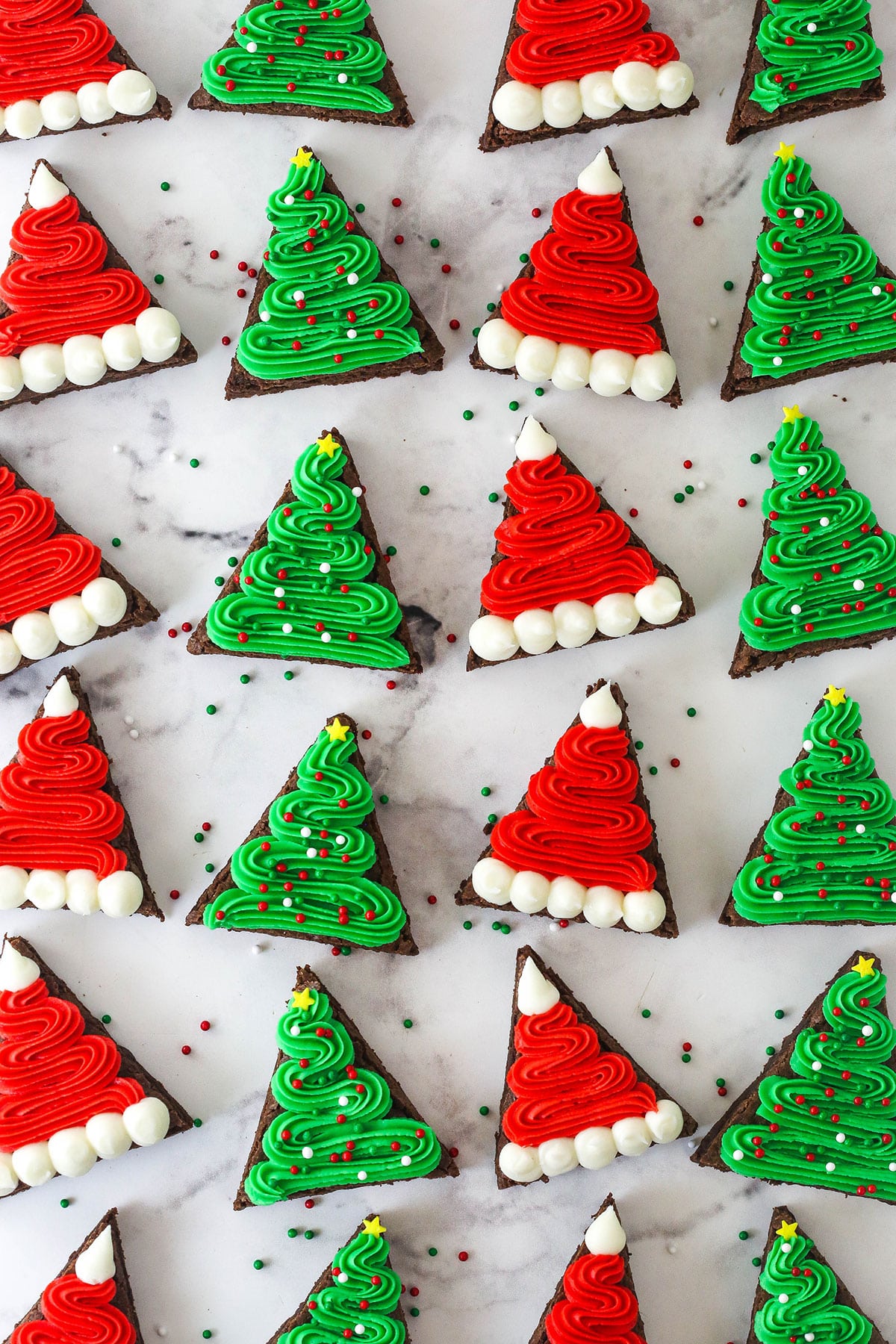 finished christmas tree and santa hat brownies on marble background