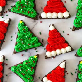 finished christmas tree and santa hat brownies on marble background, close up