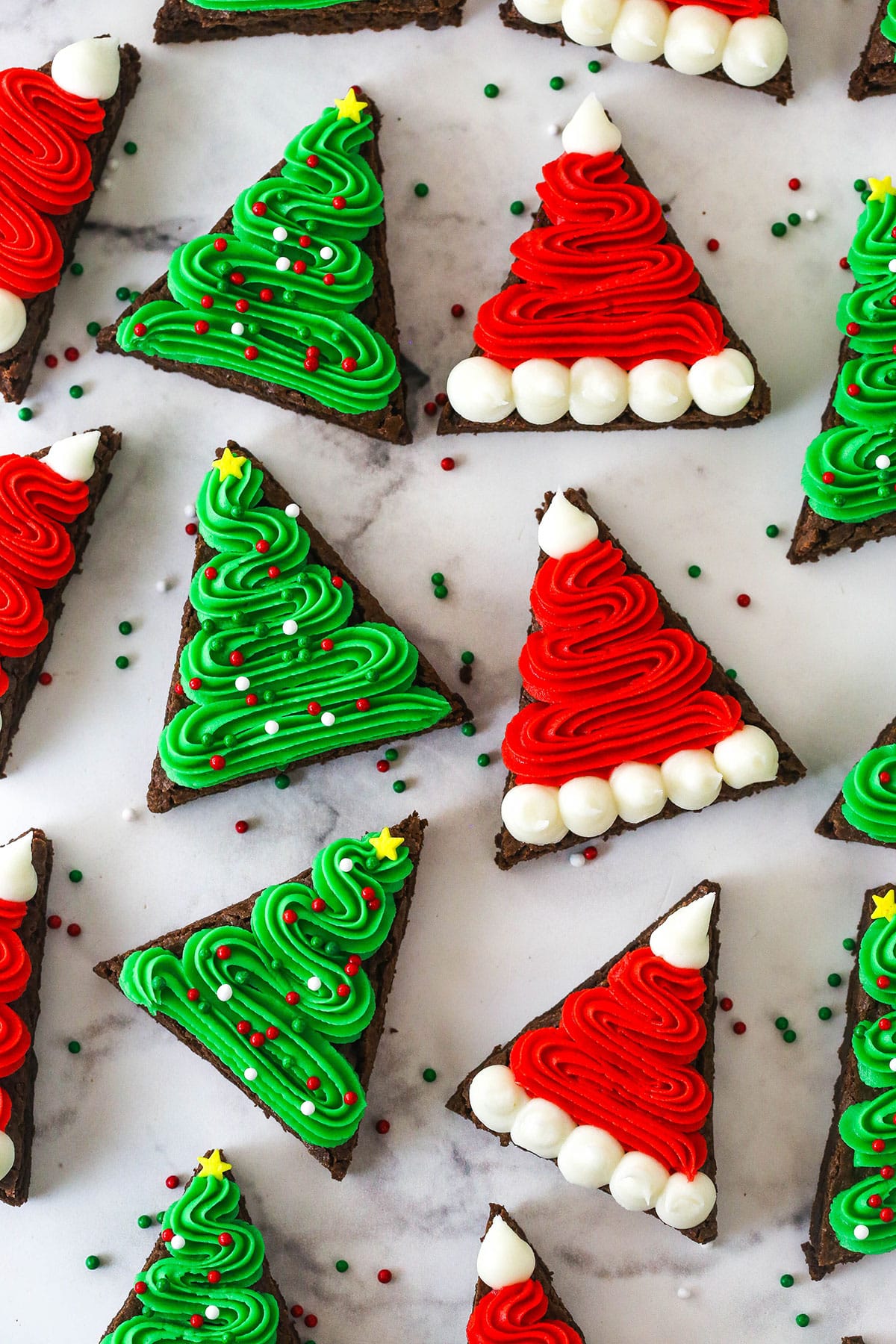 finished christmas tree and santa hat brownies on marble background, close up
