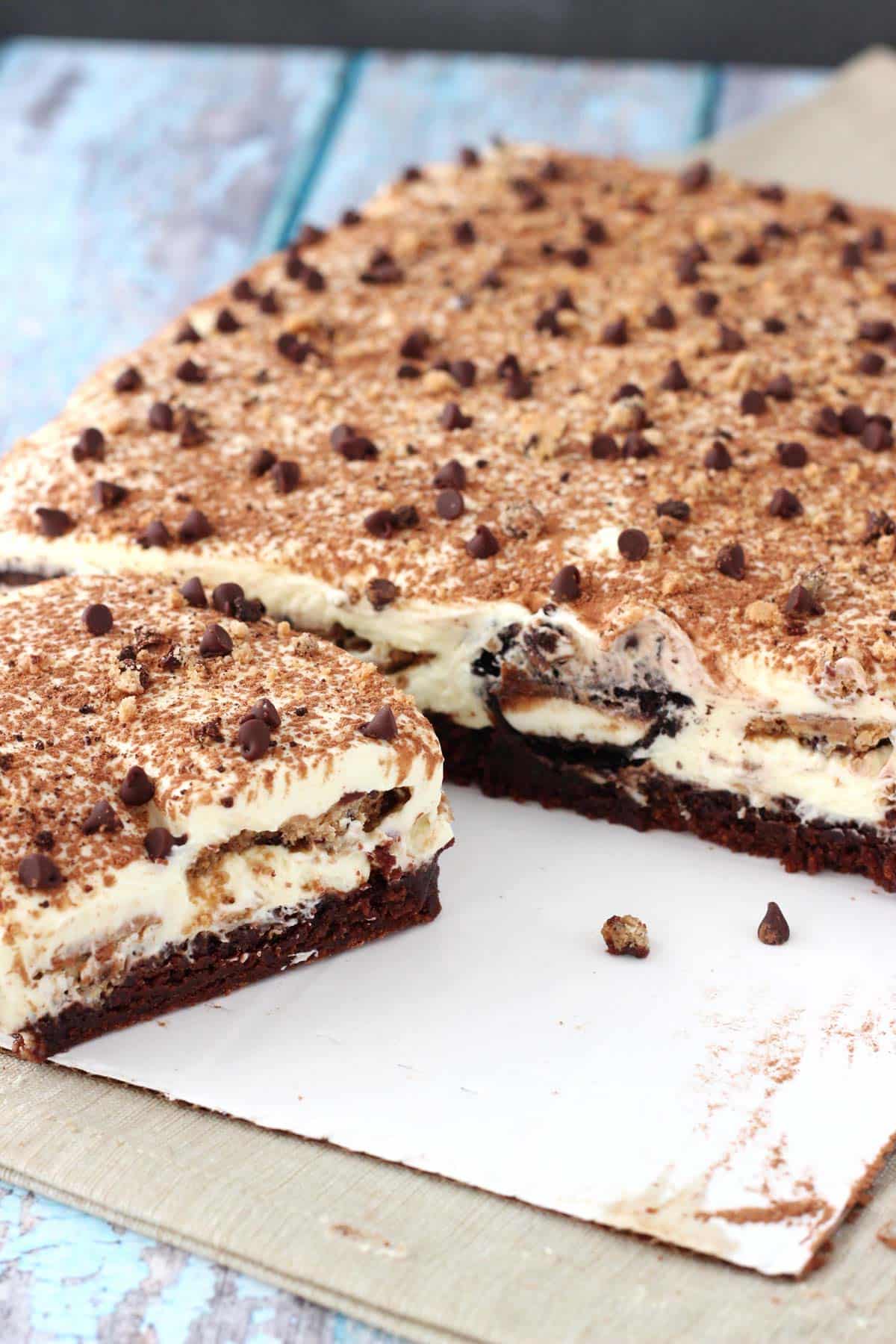 A slab of Oreo brookie tiramisu with a slice being removed.