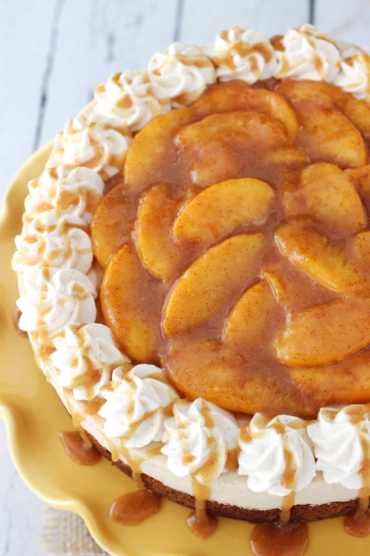 Top view of a peach caramel blondie cheesecake on a yellow cake stand.