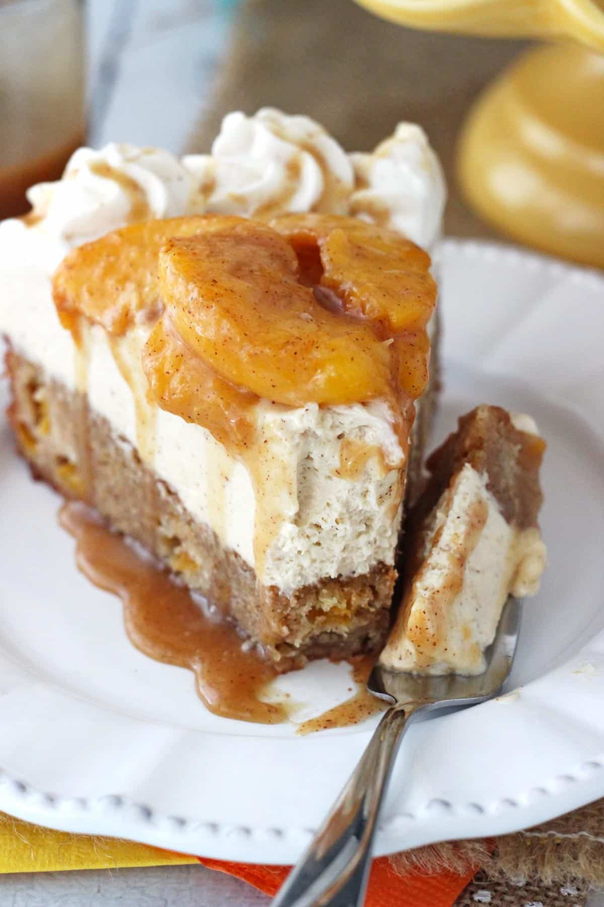A slice of peach caramel blondie cheesecake with a bite removed on a fork.