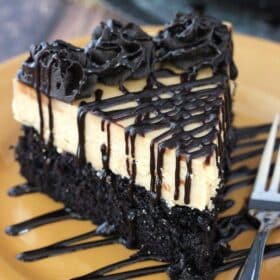 A slice of peanut butter truffle chocolate cake on a gold plate.