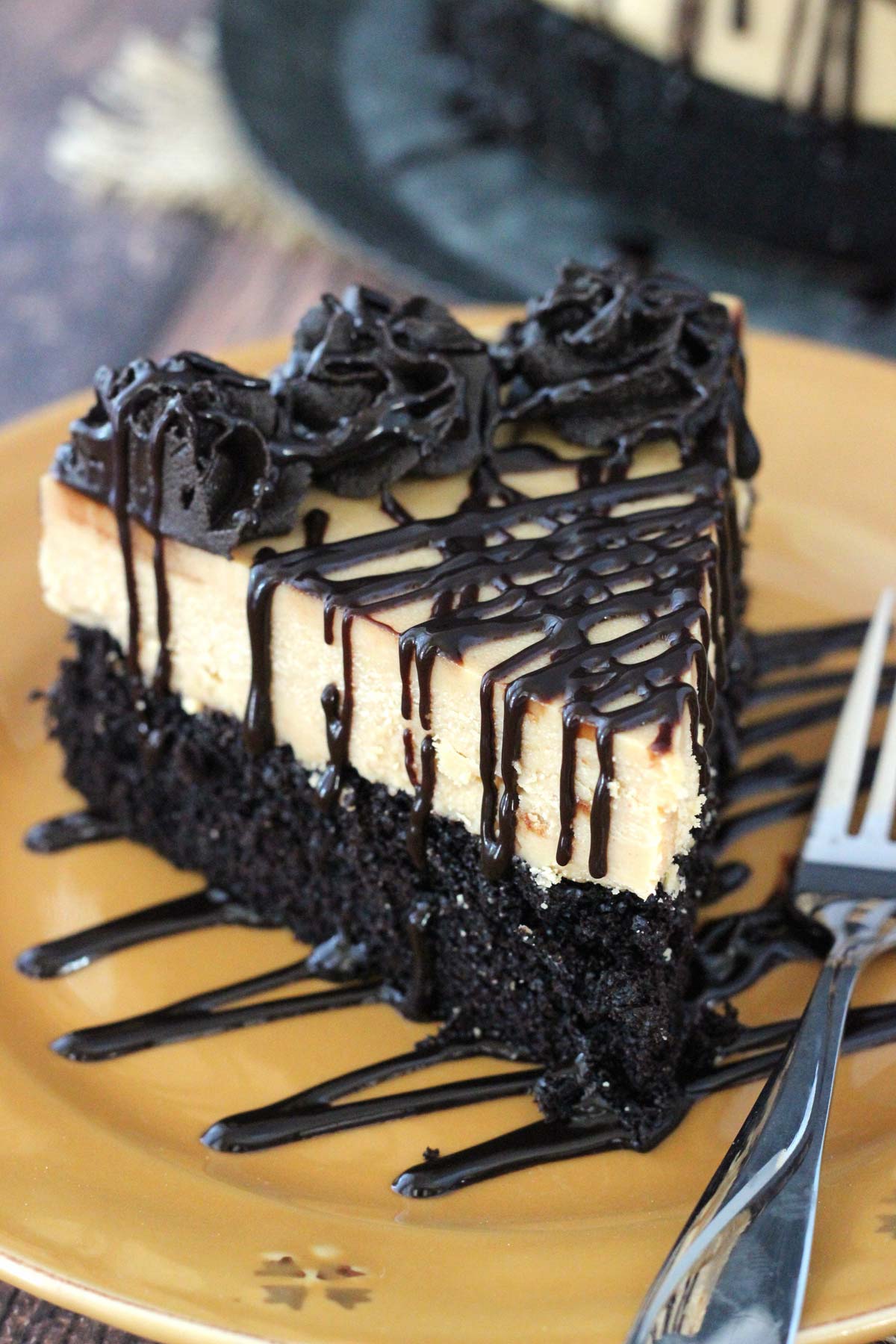 A slice of peanut butter truffle chocolate cake on a gold plate.