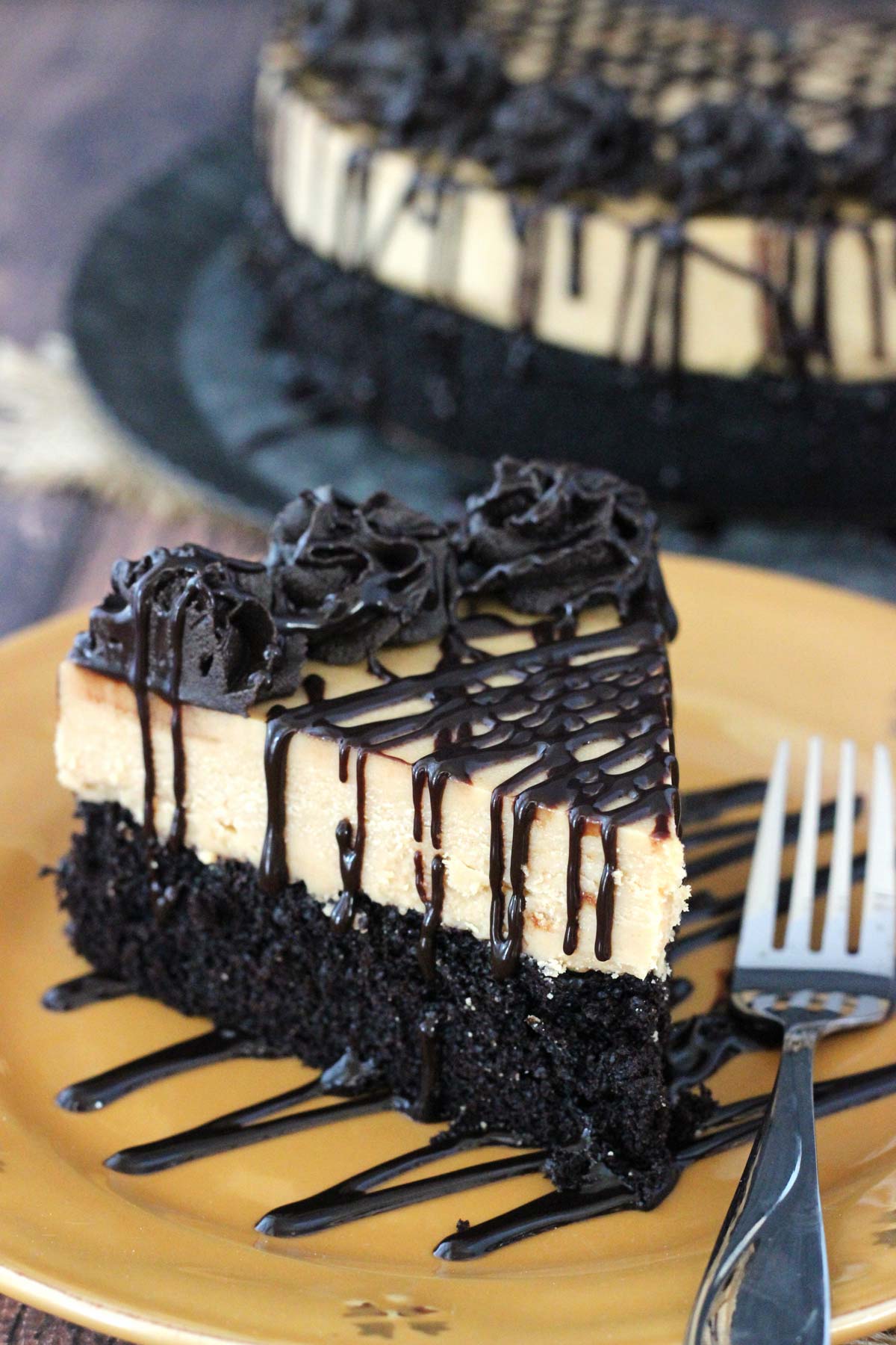 Close up of a slice of peanut butter truffle chocolate cake on a gold plate.