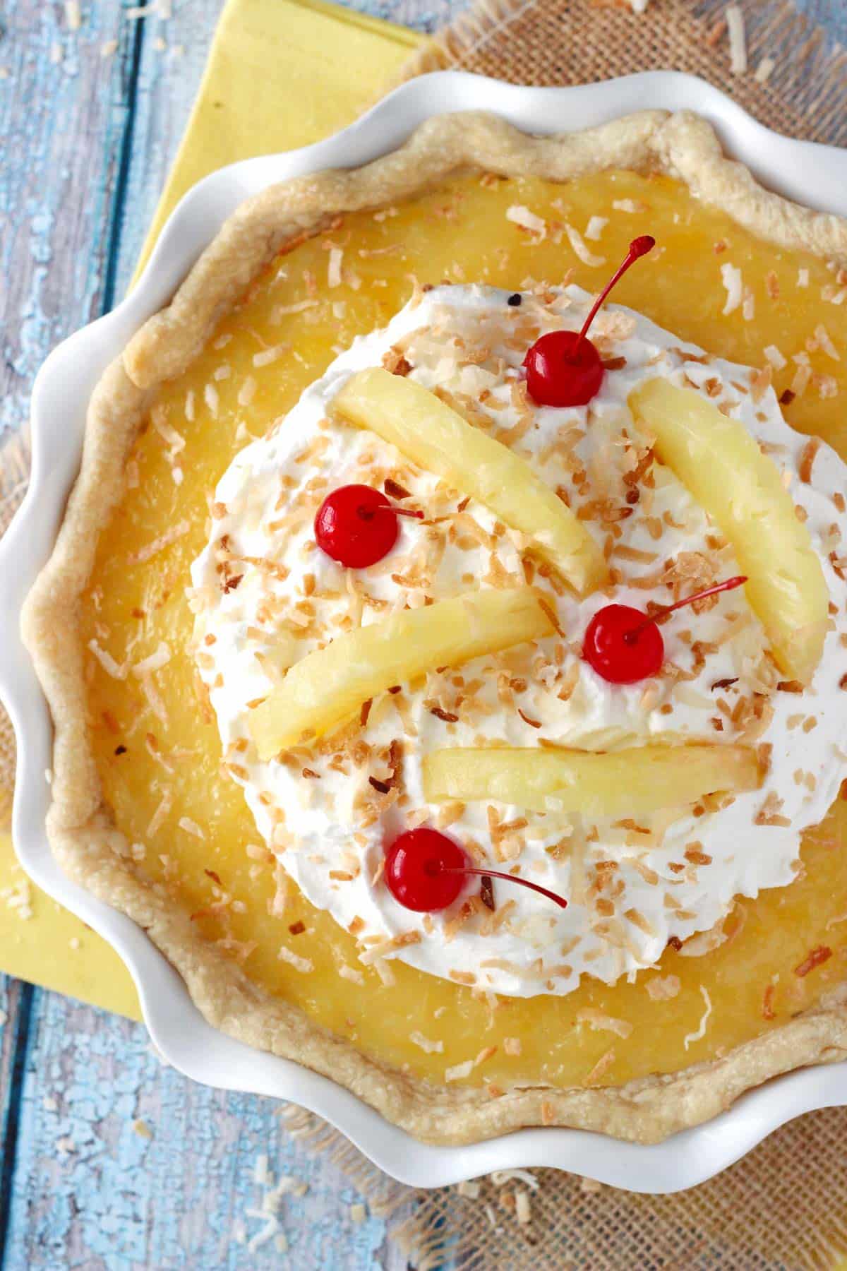 Top view of a pina colada pie in a white ruffled pie plate.