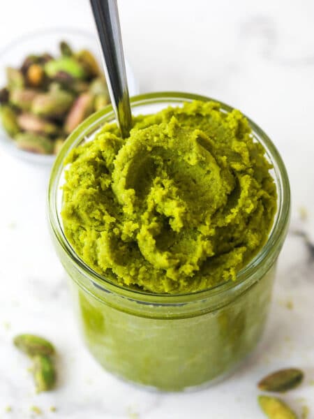 Overhead view of a jar of pistachio paste with a spoon