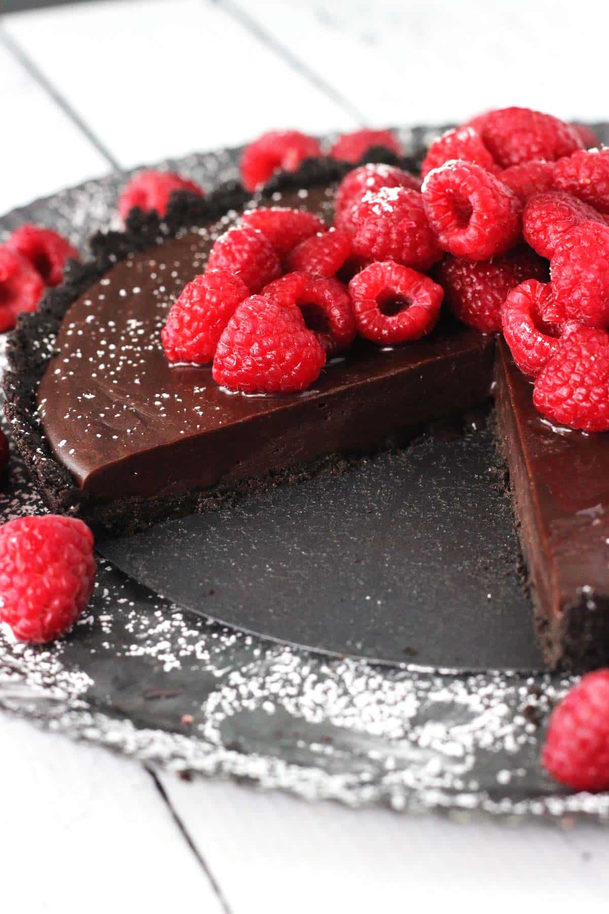 A raspberry nutella tart with a slice removed to show interior.