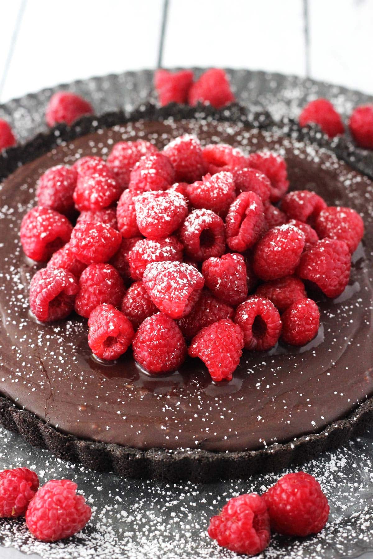 Top view of a raspberry nutella tart sprinkled with powdered sugar.