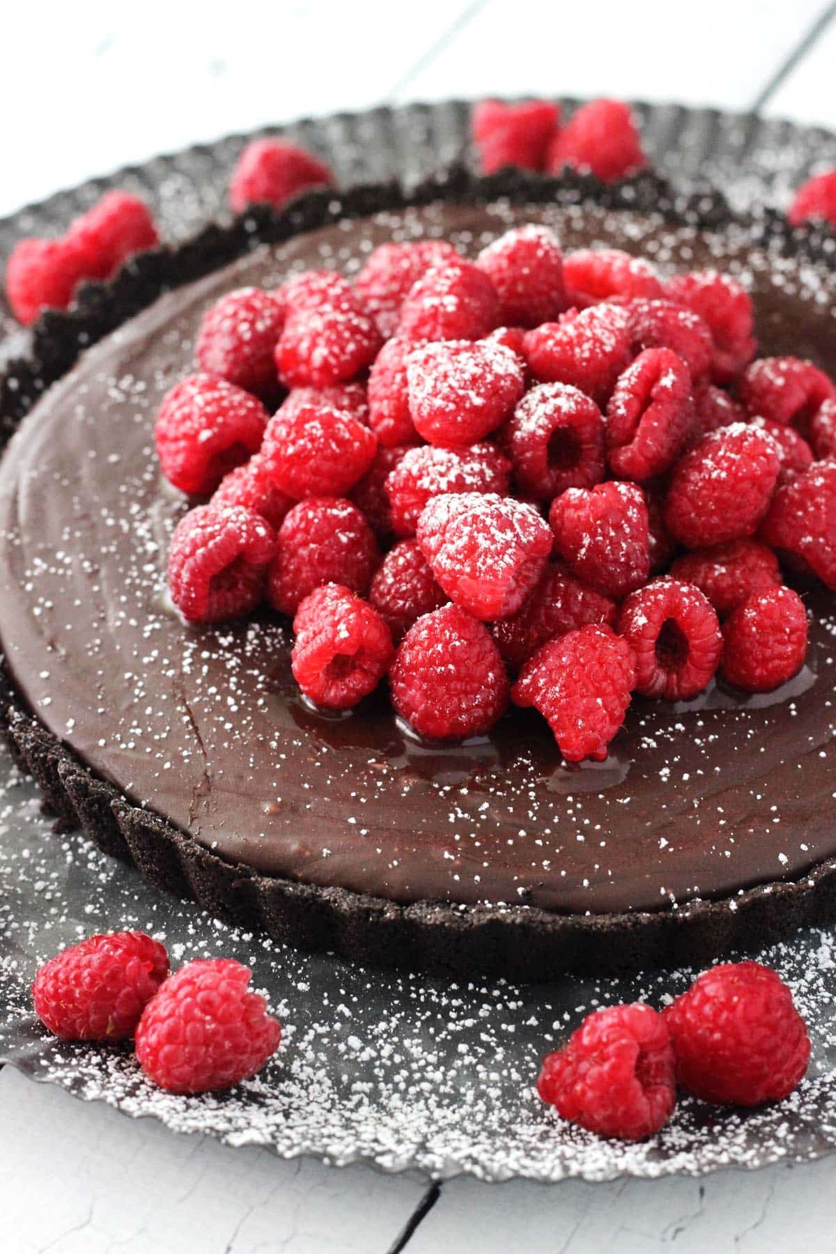 Close up of a raspberry nutella tart sprinkled with powdered sugar.