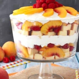 Close up of a raspberry peach sangria trifle in a glass trifle bowl.