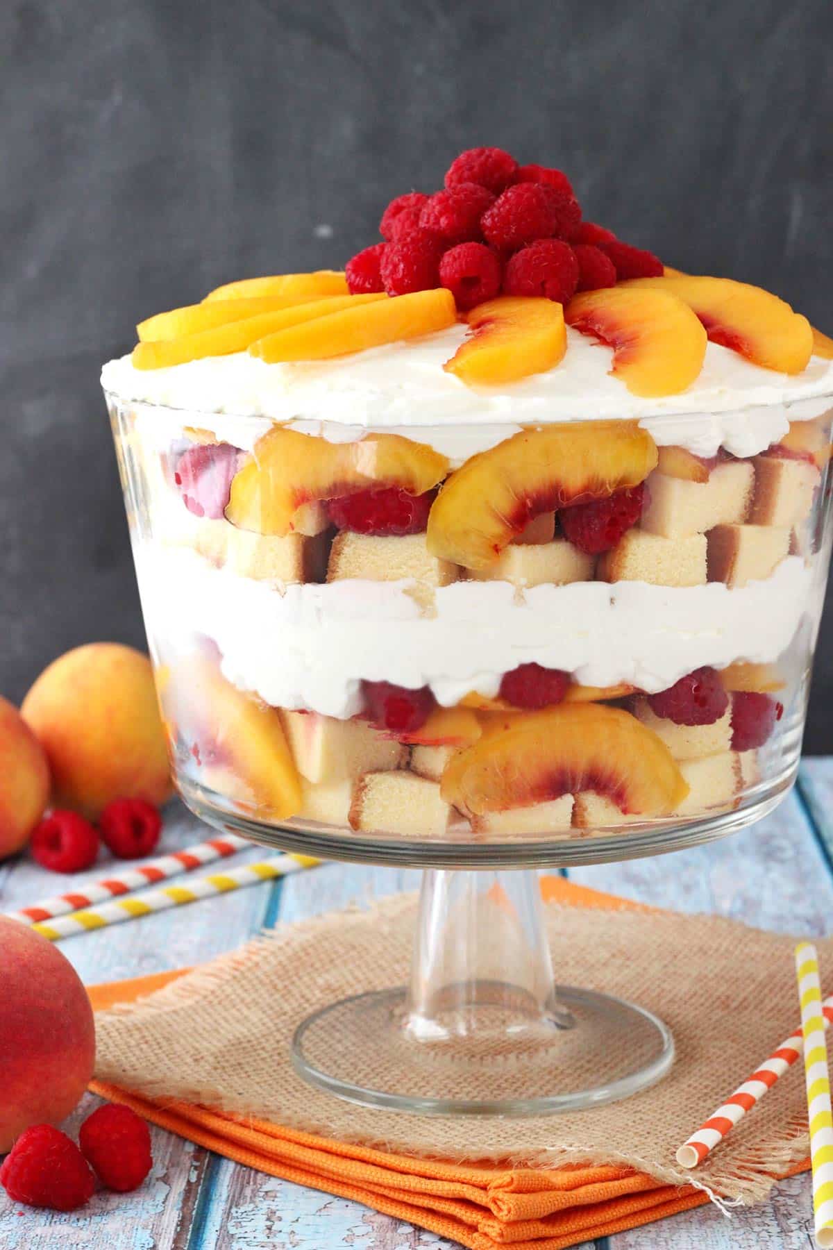 Close up of a raspberry peach sangria trifle in a glass trifle bowl.