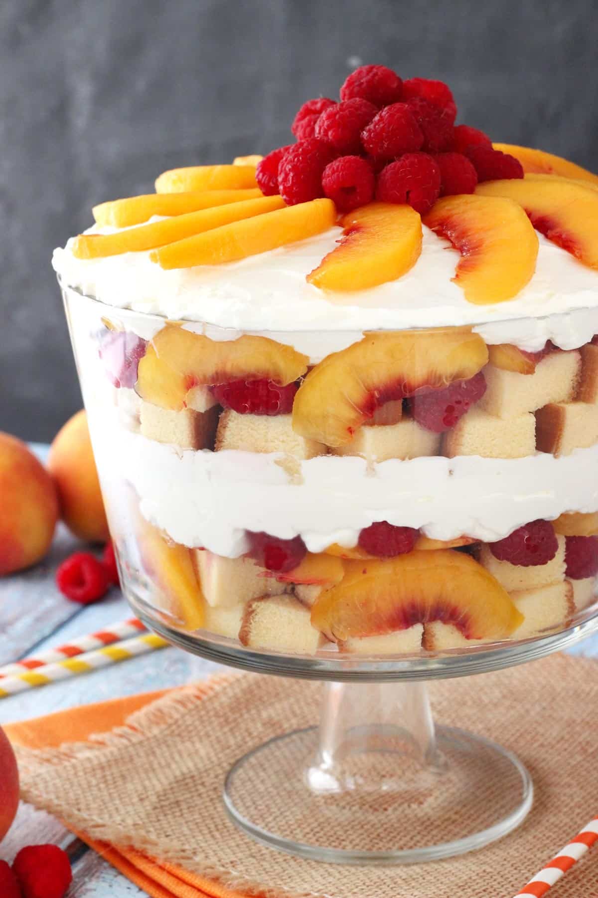Side view of a raspberry peach sangria trifle in a glass trifle bowl.