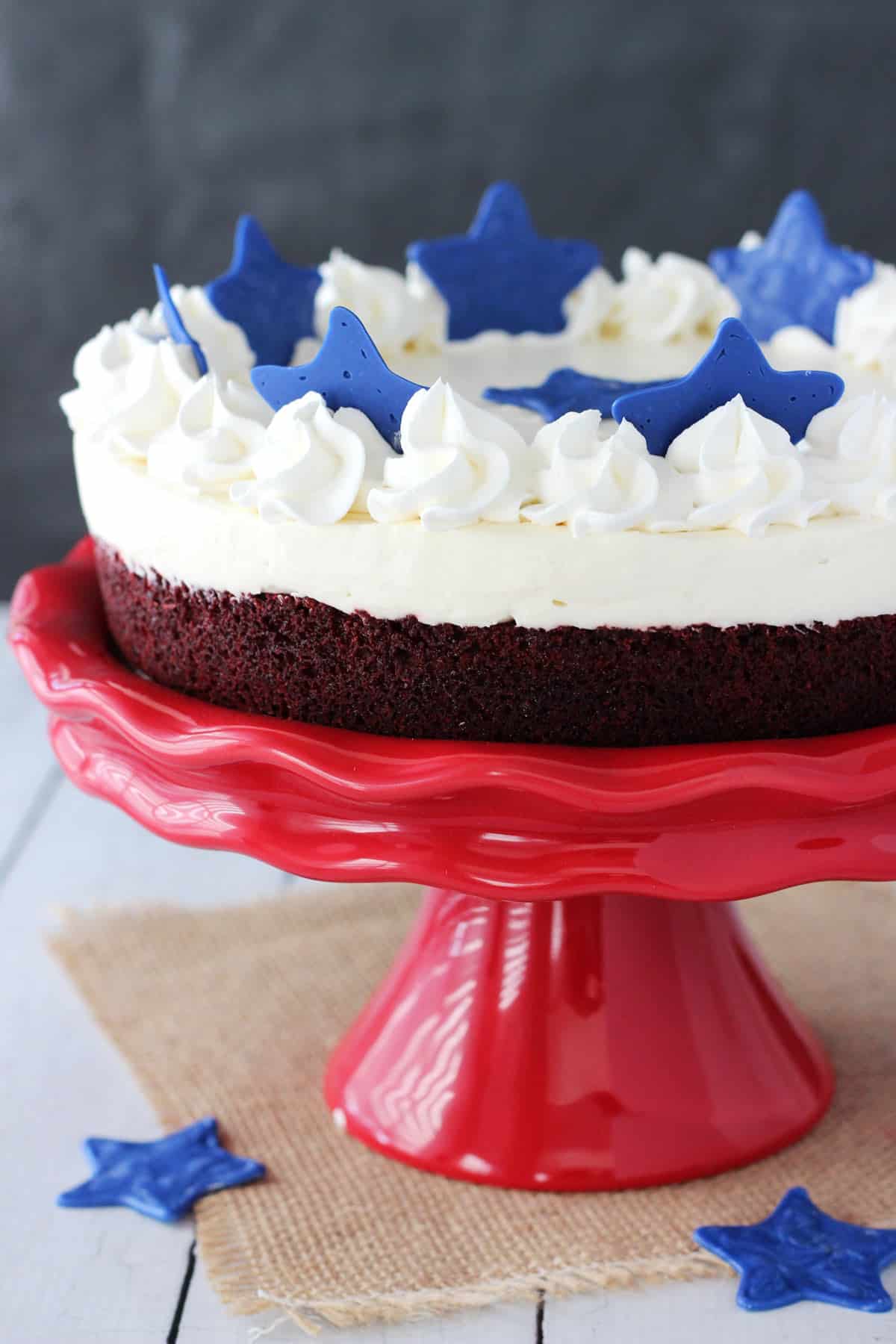 Close up of a red velvet blondie cheesecake on a red cake stand.