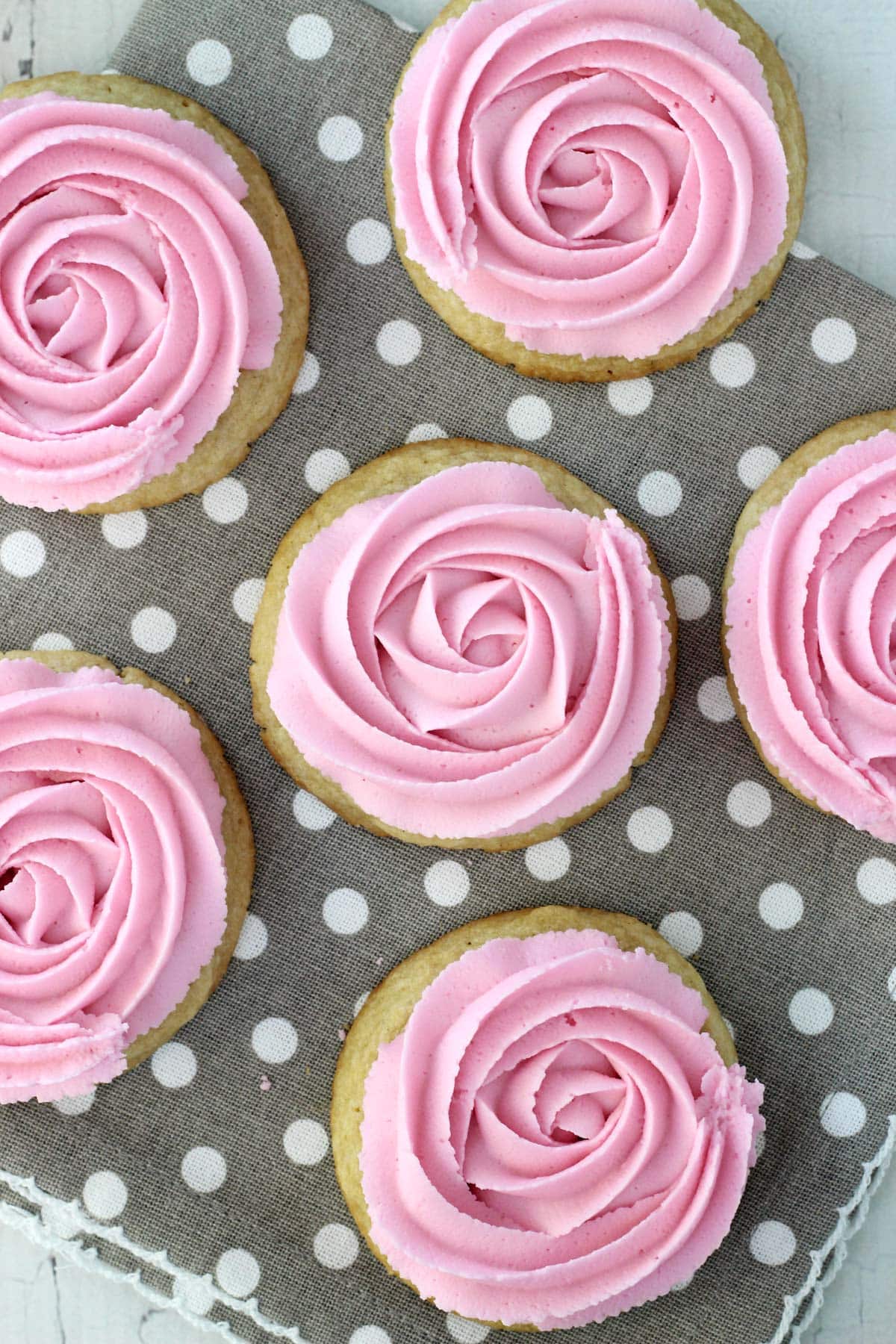 Top view of rosette sugar cookies on a grey and white polka dot napkin.