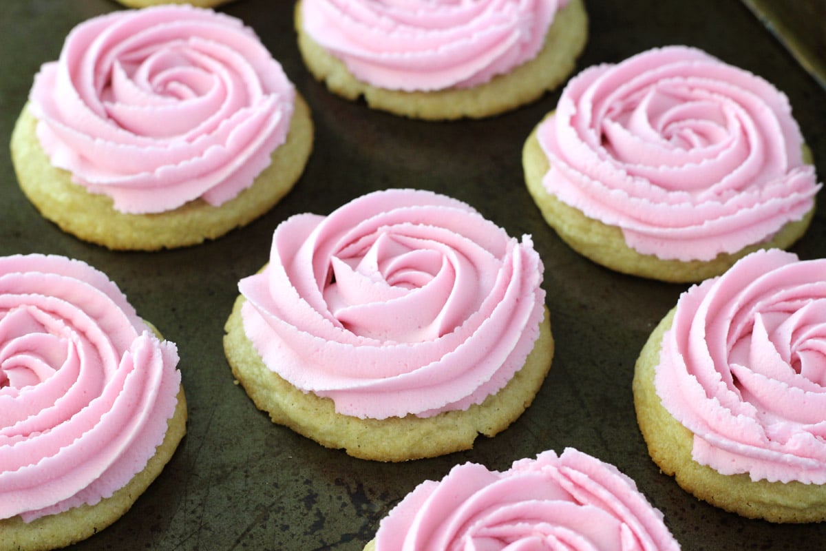 Close up of rosette sugar cookies on a baking sheet.